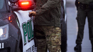 Police officer opening police car door in the pouring rain